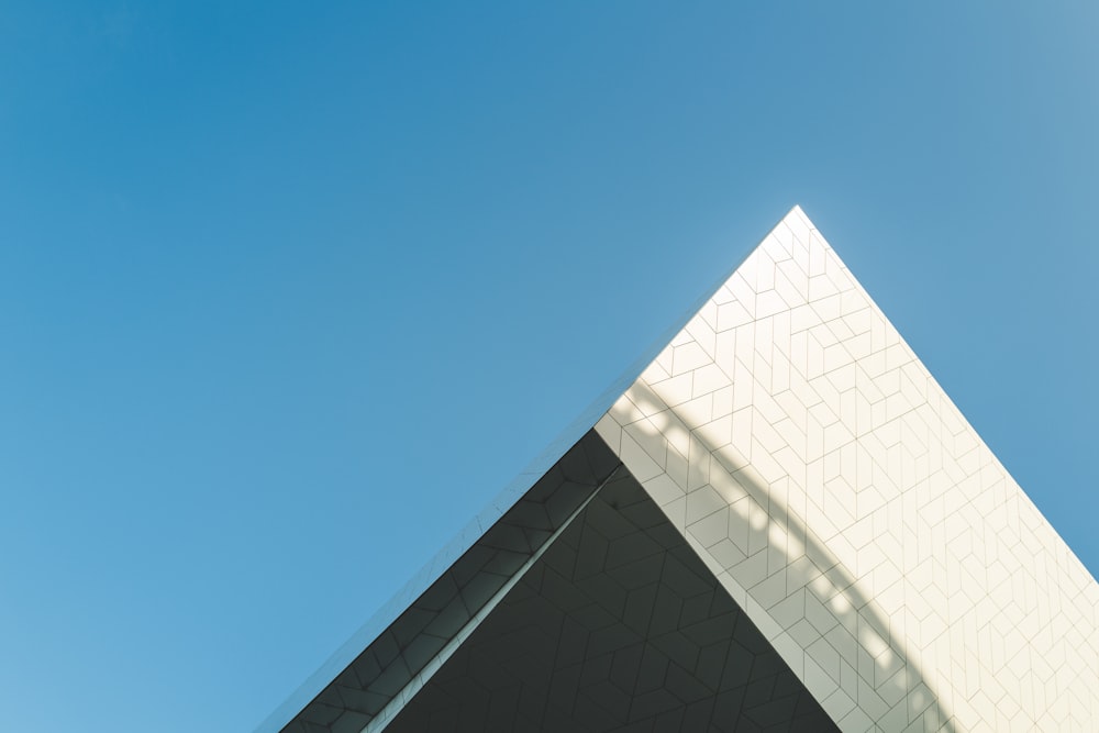 a building with a triangular roof and a blue sky in the background