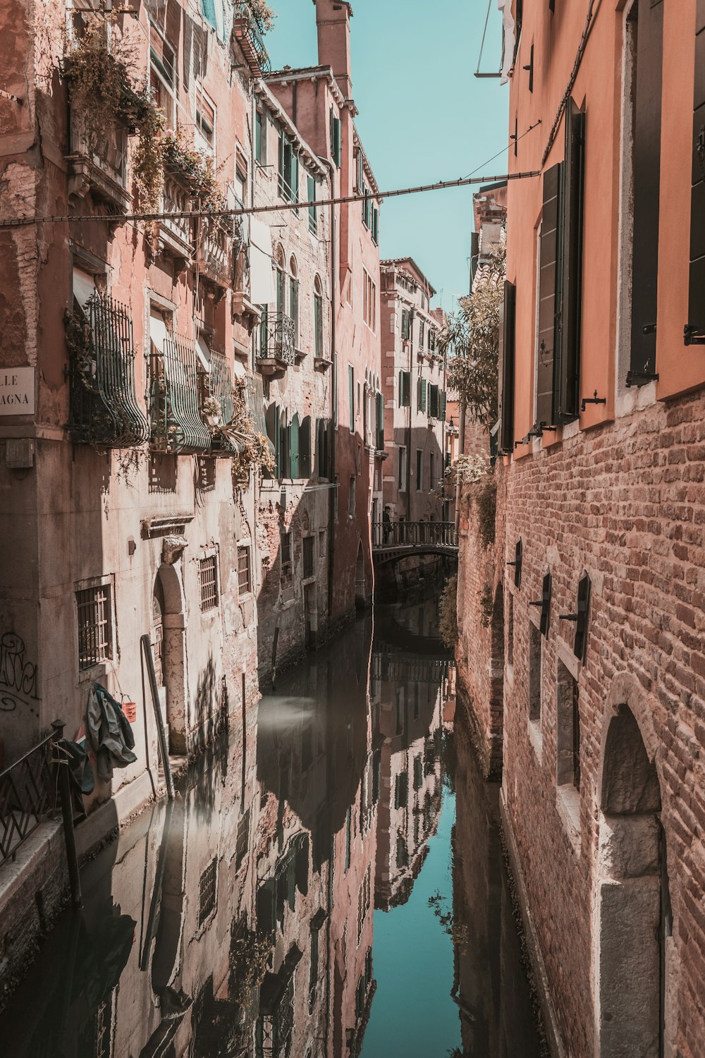 canal between brick buildings at daytime