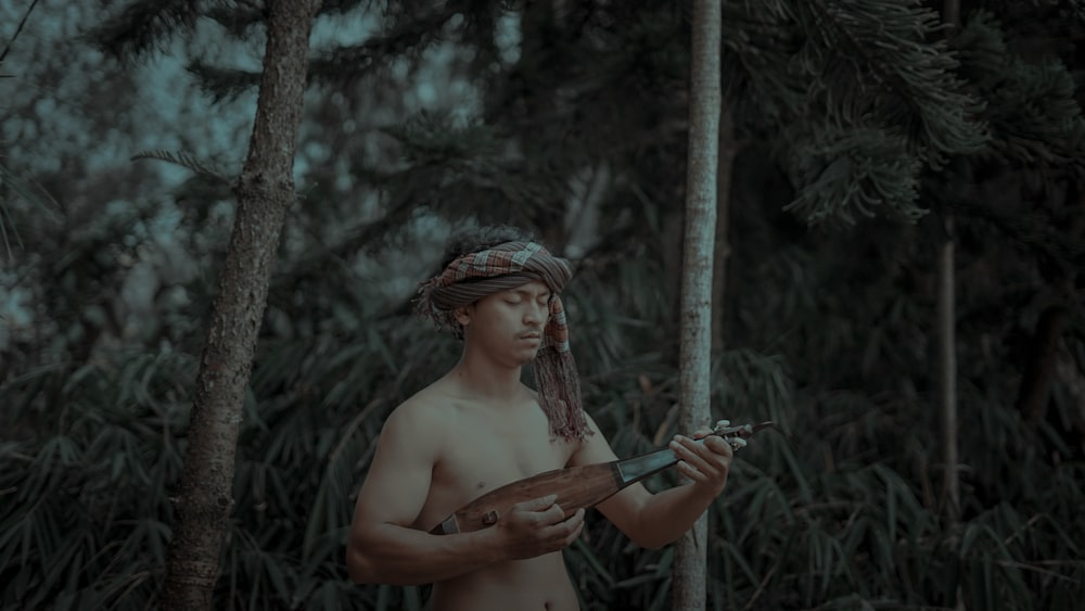 topless man using music instrument