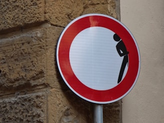 Man hiding behind signage on a brick wall, symbolizing the silence and stigma around men's hormone 