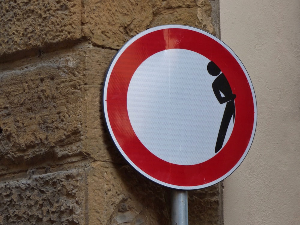 homme cachant des panneaux sur un mur de briques