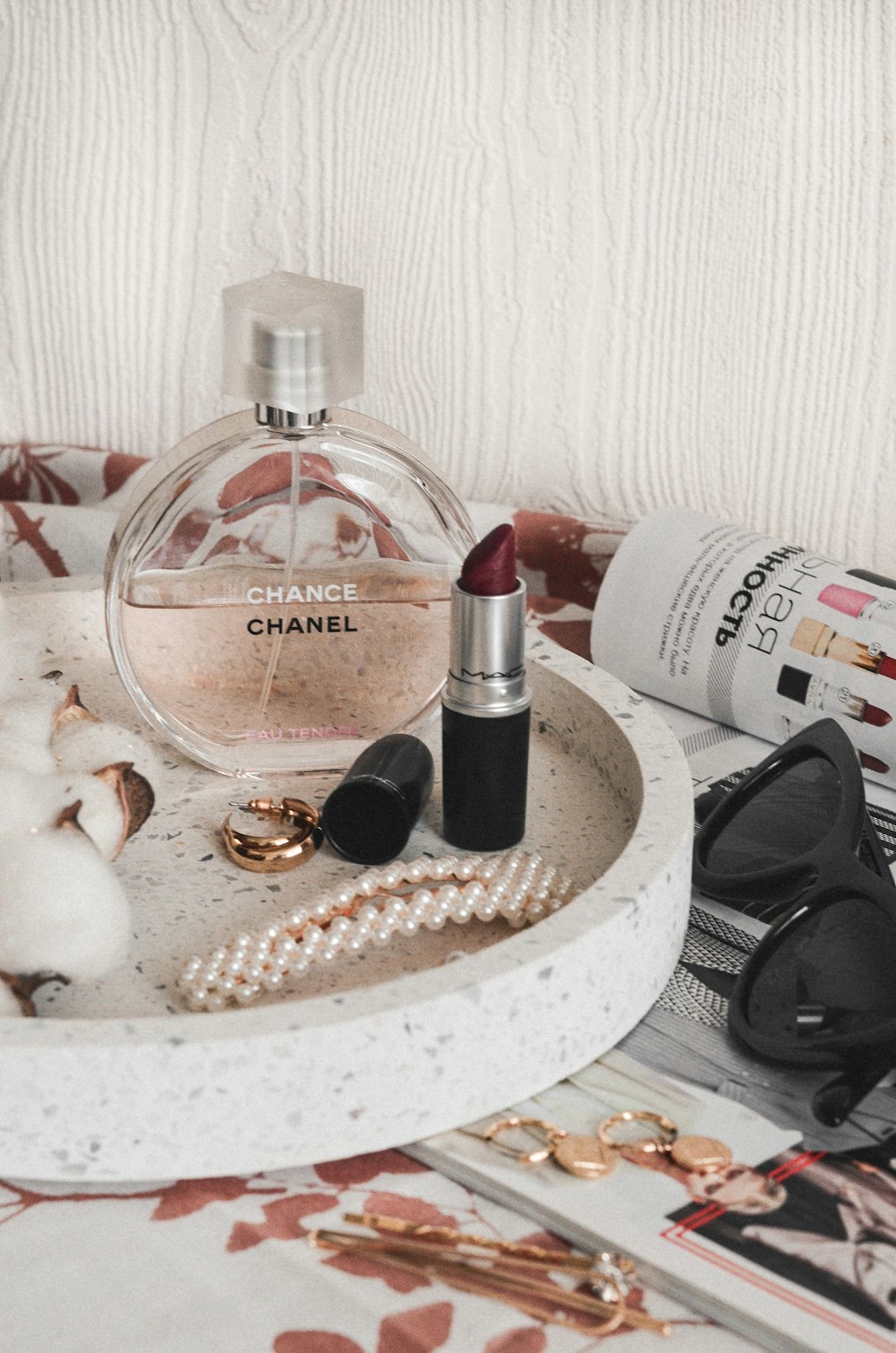 Chanel perfume bottle beside maroon lipstick