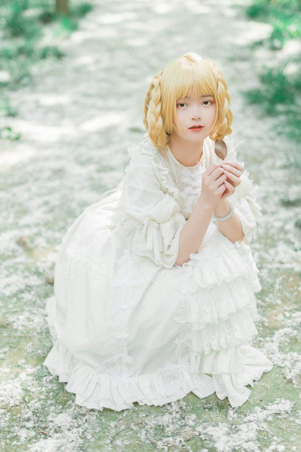 woman sitting on ground wearing white ruffled long-sleeved dress