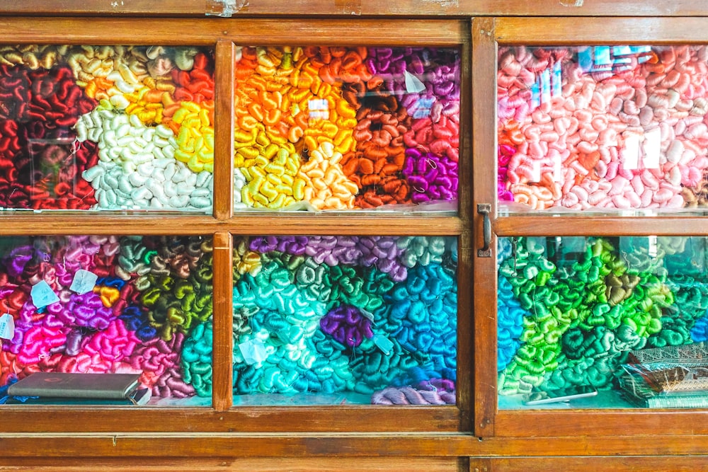 assorted-color textiles in brown wooden cabinet