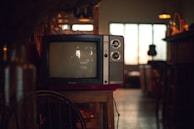 A technician troubleshooting a television set in a cozy workshop environment.