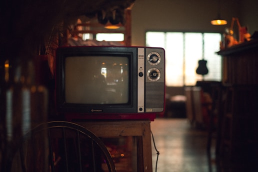 A vintage television set glowing softly in a dimly lit living room, surrounded by nostalgic memorabilia from the 1980s.