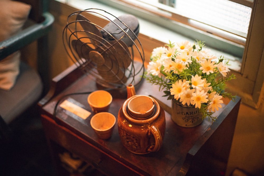 flowers in vase beside teapot