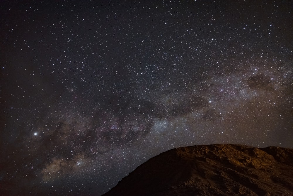 mountain and sky with stars during night