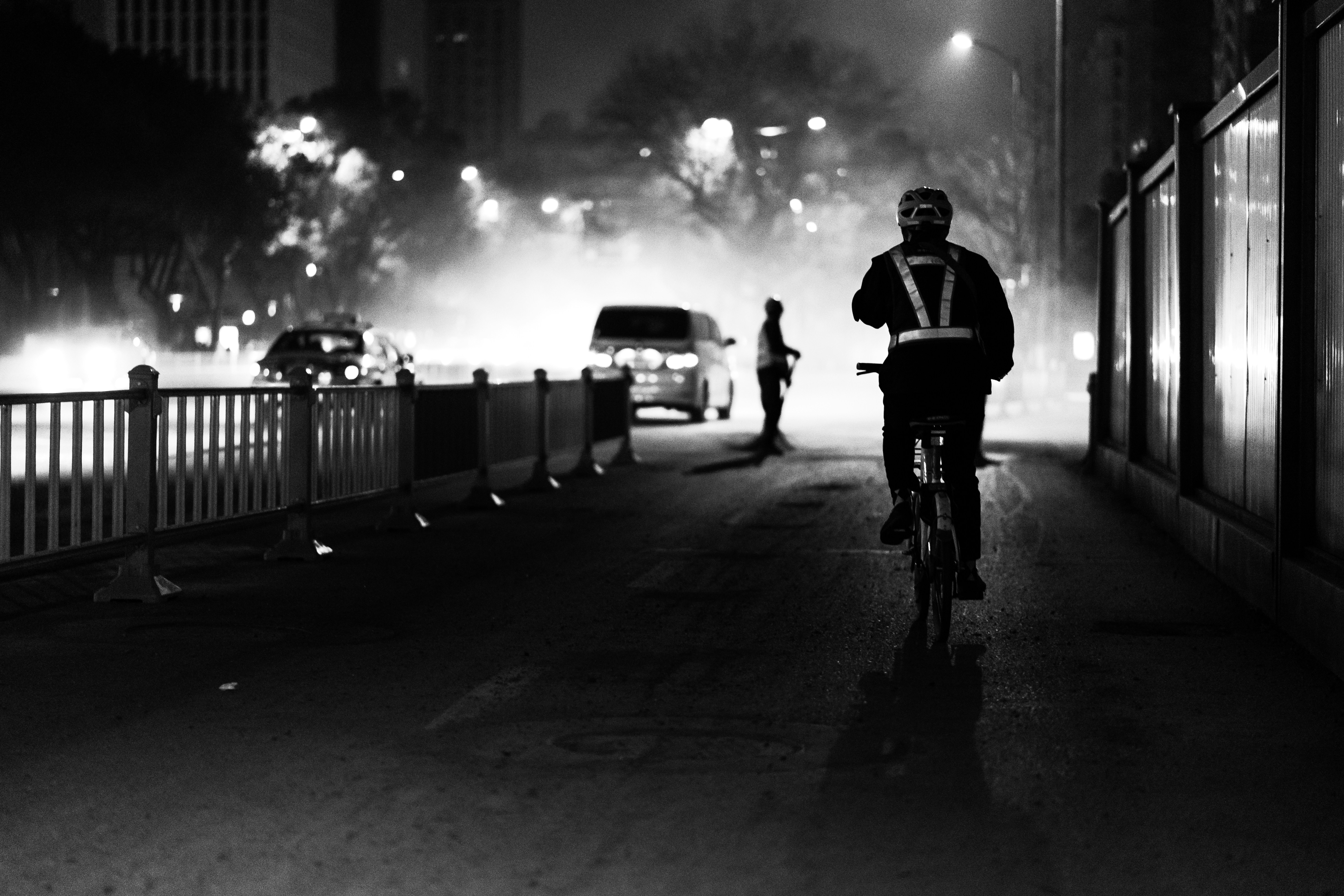 Foto in scala di grigi di un uomo in sella alla bicicletta
