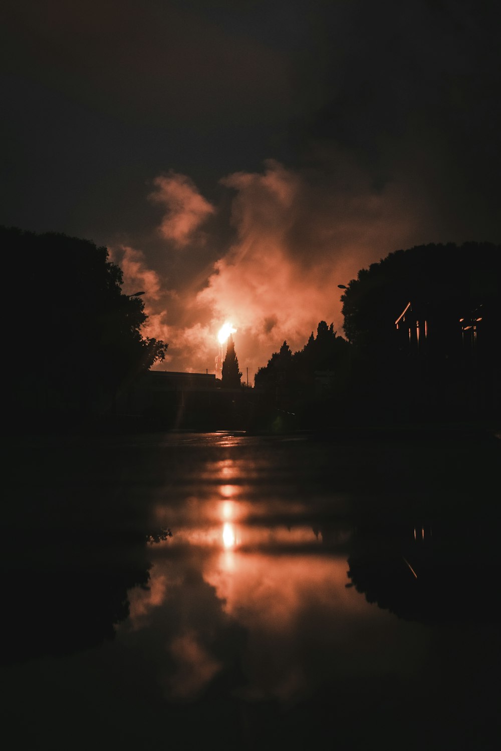 silhouette d’un bâtiment près d’un plan d’eau au coucher du soleil