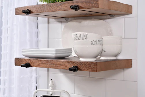 Bright kitchen with open shelves displaying colorful dishes and rustic decor.