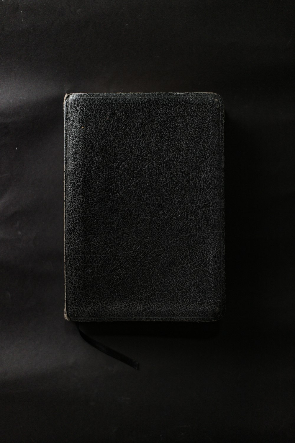 black leather wallet on black textile