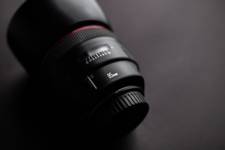 Close-up of a sleek black and gold luxury lens reflecting soft studio lighting.