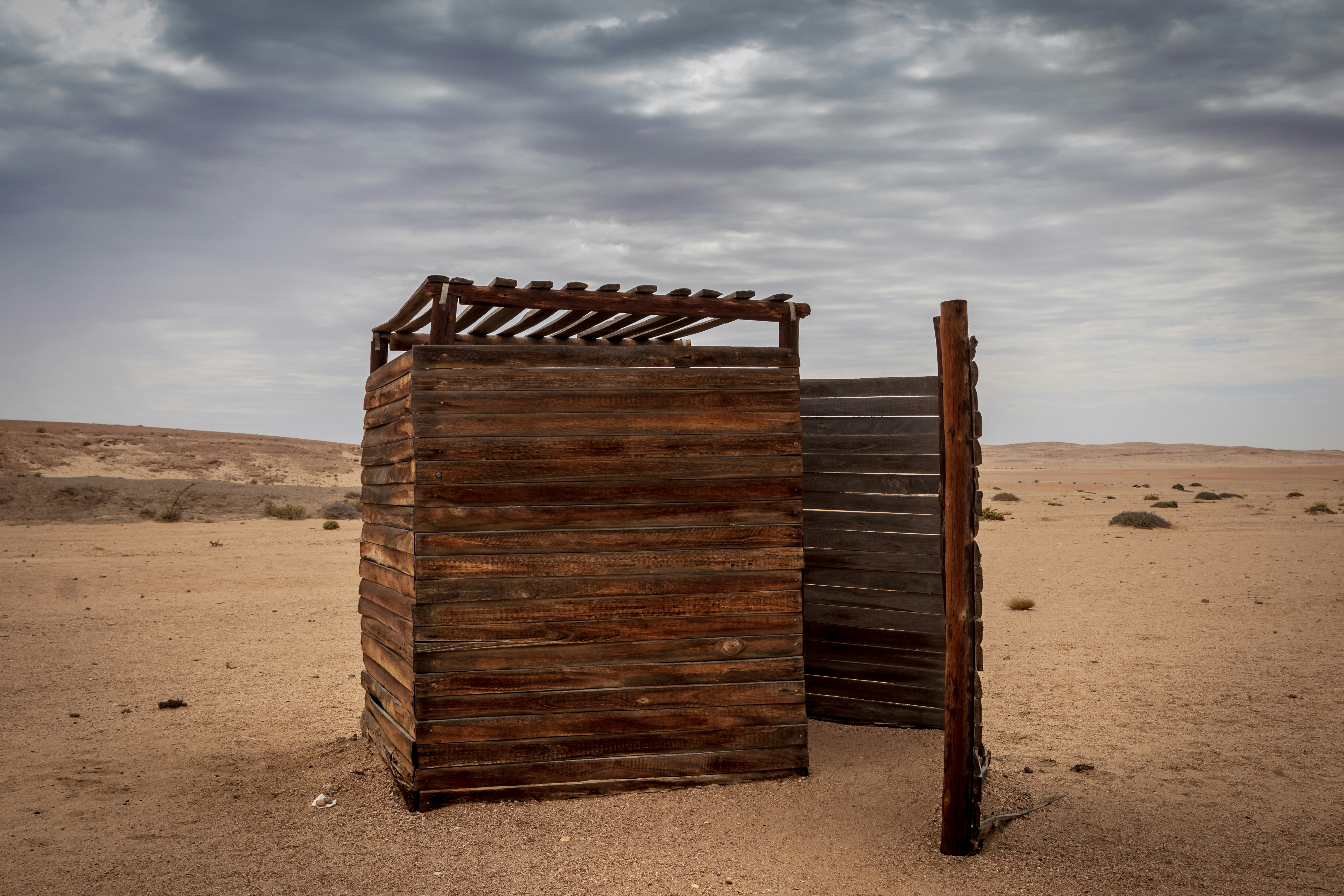 brown wooden shed, "Restrooms" at Welwitschia Plain outside of Swakopmund, Namibia