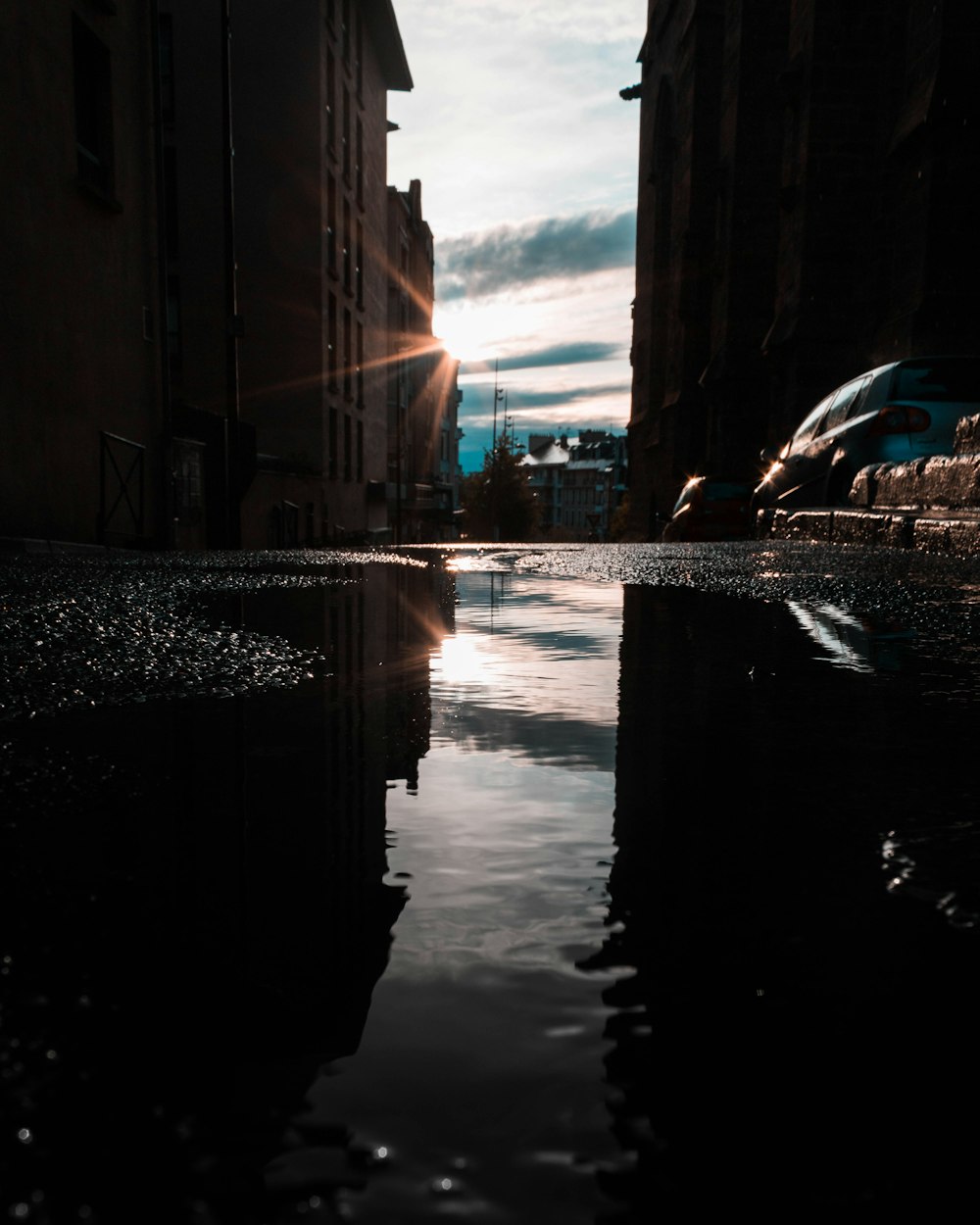 a city street with a puddle of water in the middle of it