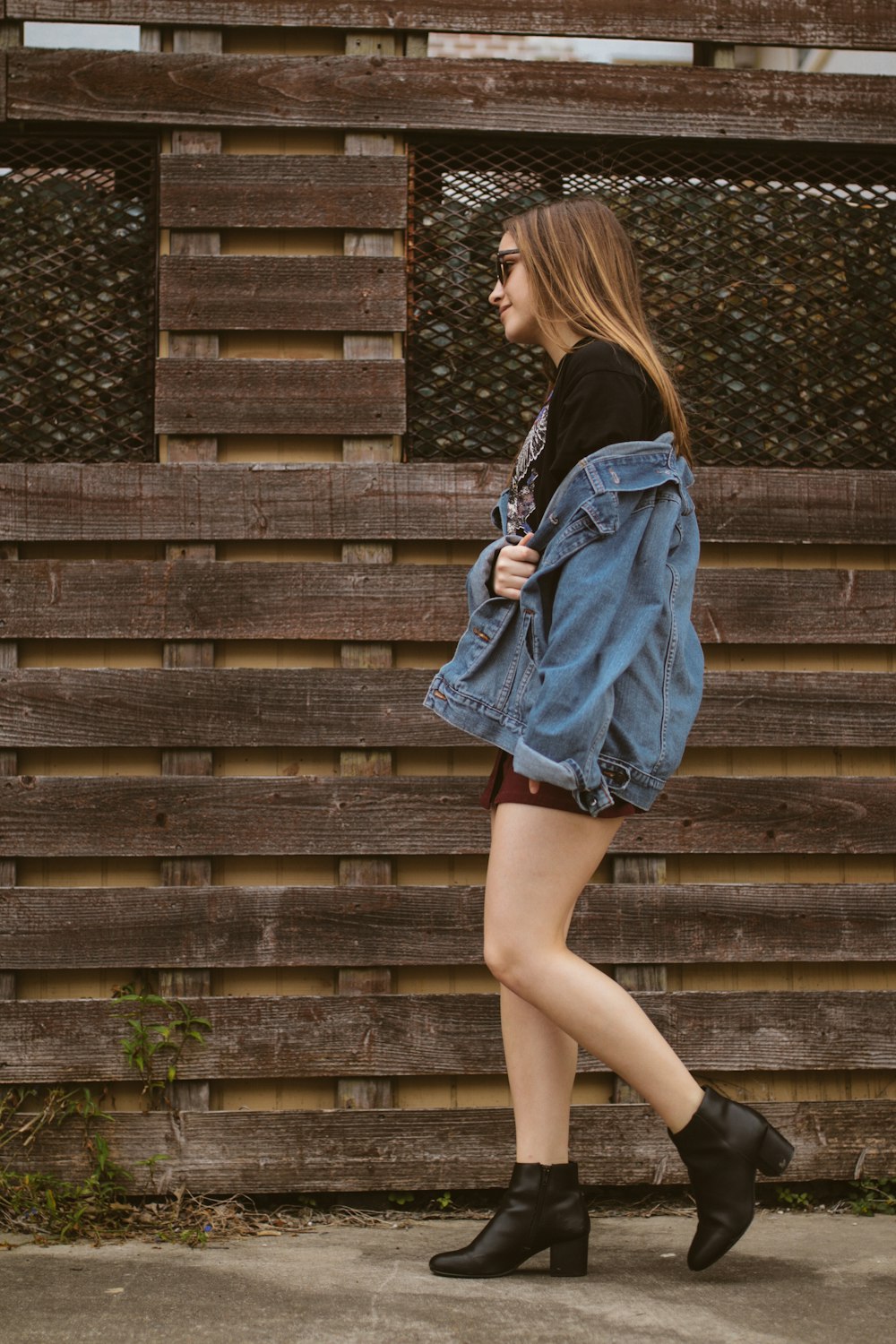 woman walking near brown wall