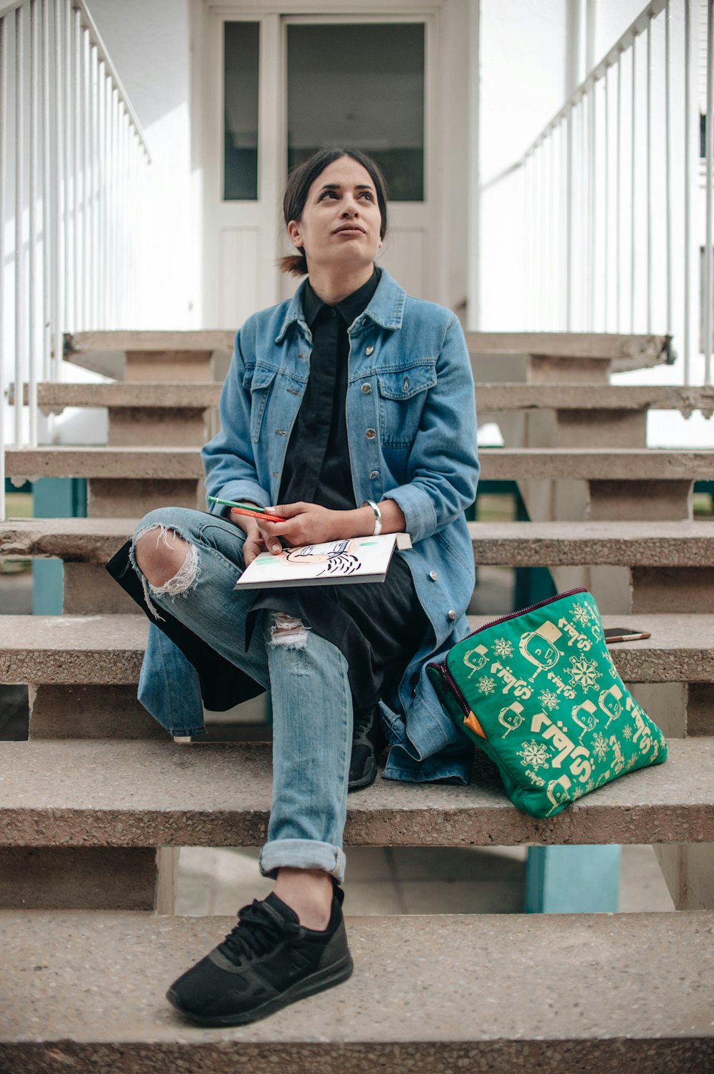 woman sitting on concrete stair with book on lap