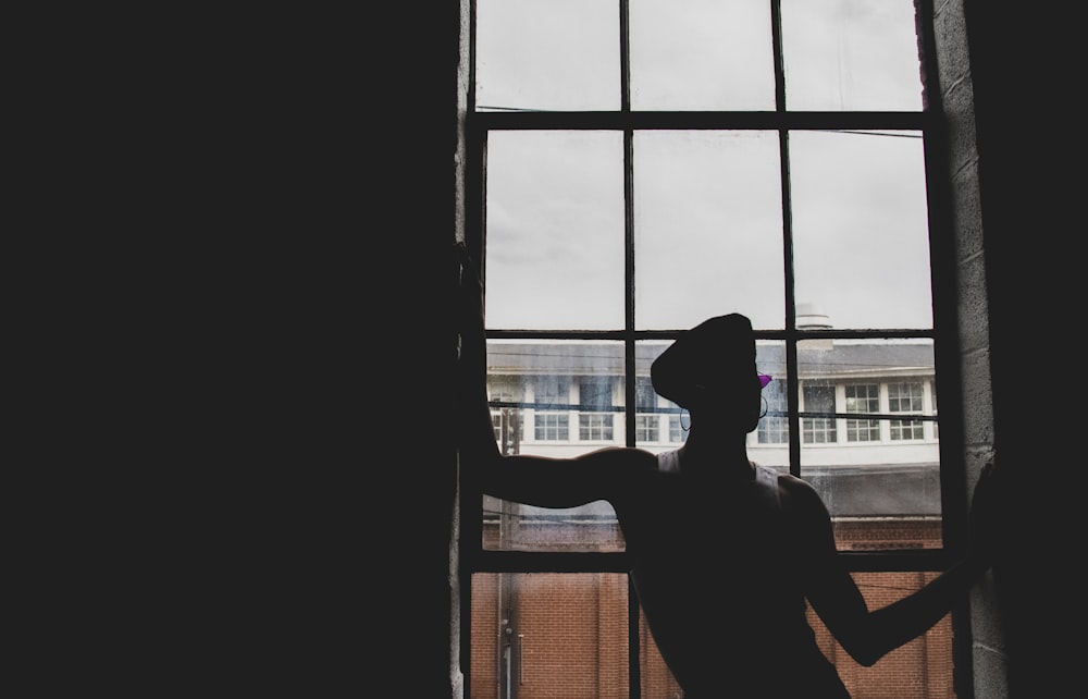 silhouette photography of person near window