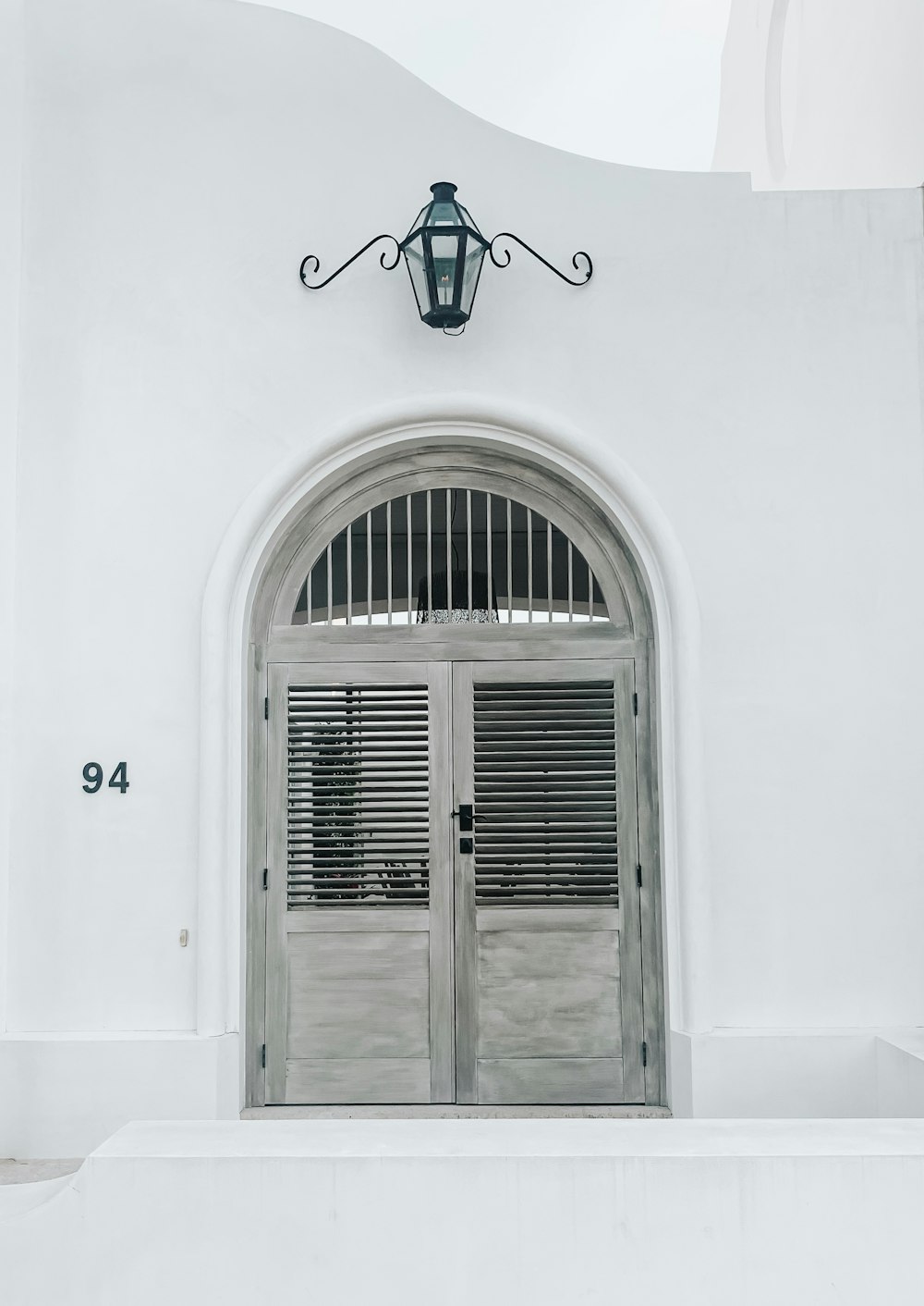 Puerta de madera gris cerrada debajo del candelabro de luz negra