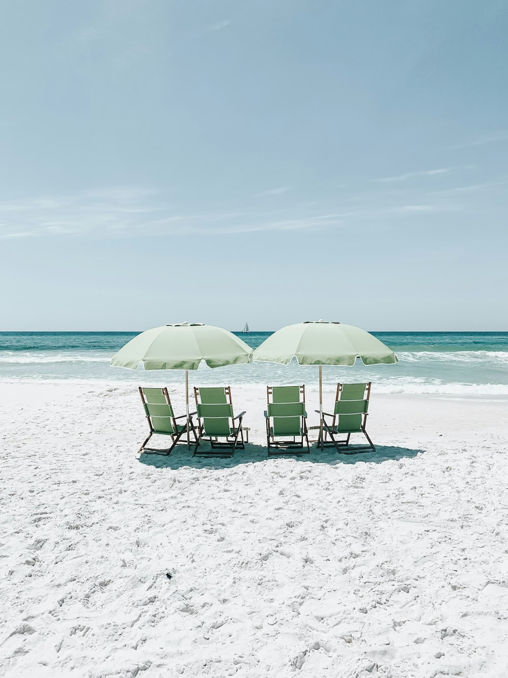 green chairs under umbrellas on shore