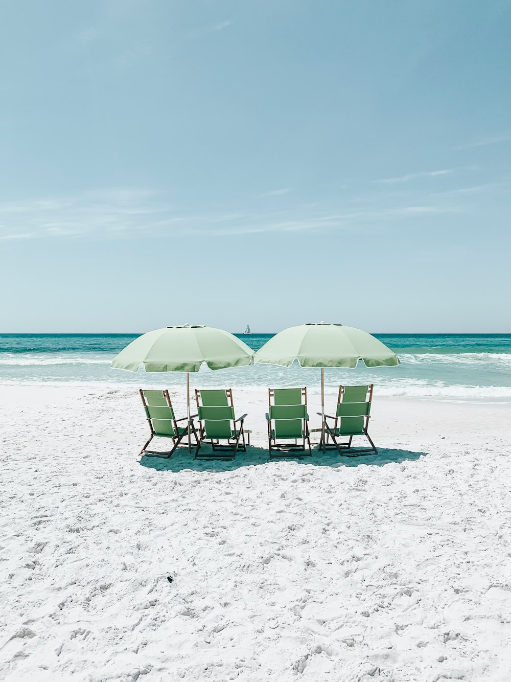 green chairs under umbrellas on shore