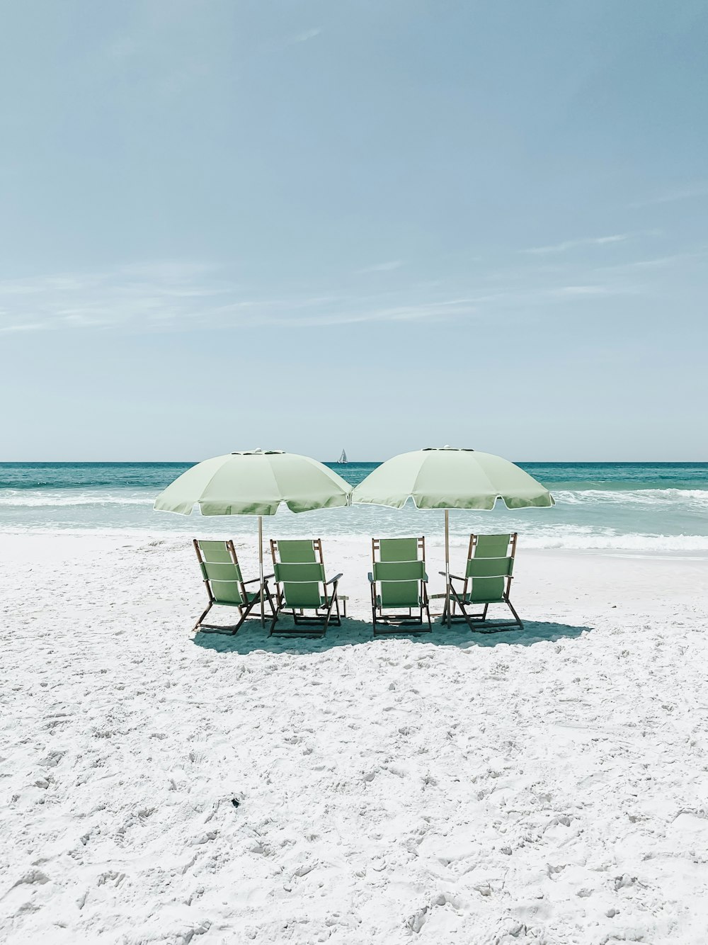 sedie verdi sotto gli ombrelloni a riva