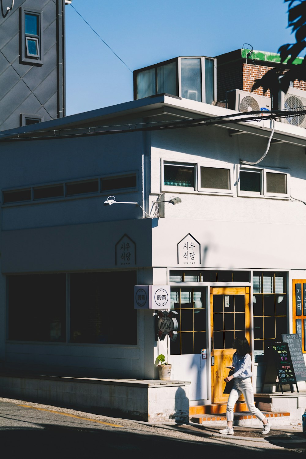 person waking in front of white building