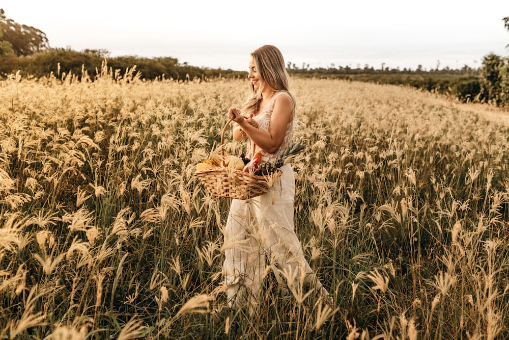 woman walking with basket of flowers at the flower field during day