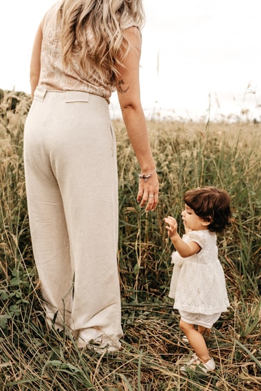 woman standing beside girl during daytime