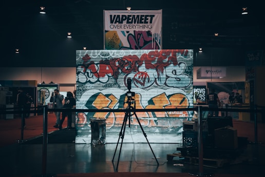 A vibrant street scene featuring a microphone, graffiti-covered walls, and an audience engaged in a live performance.