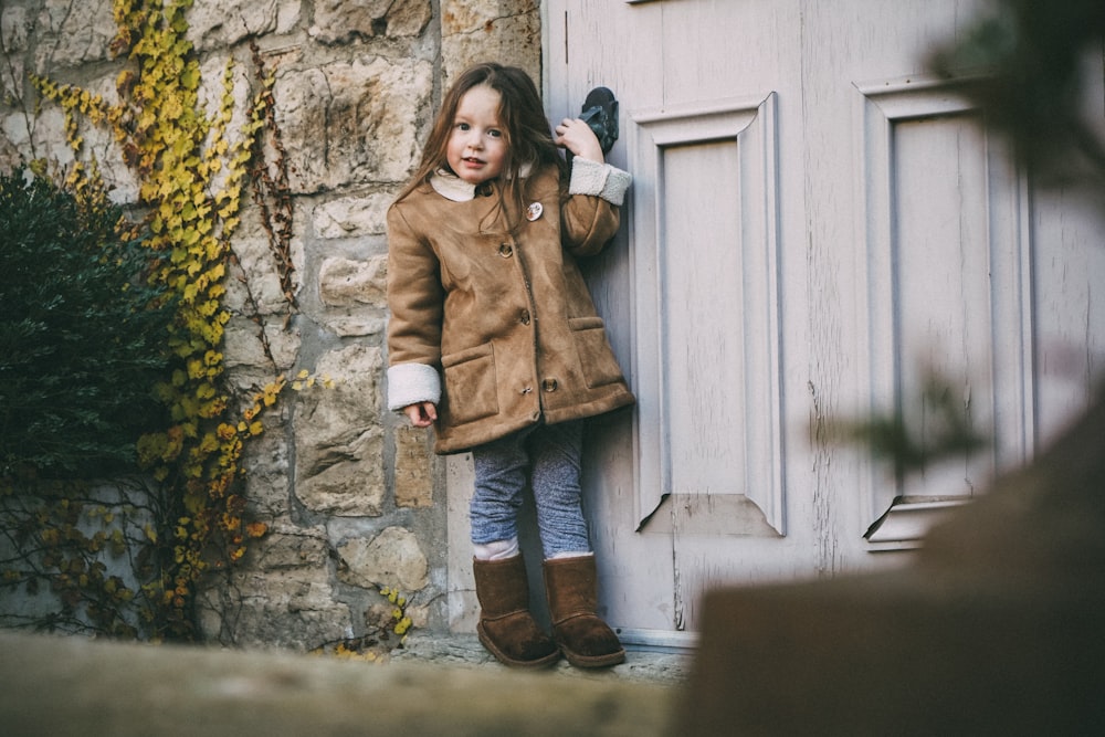 Foto de enfoque superficial de una chica con chaqueta marrón abotonada