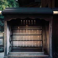 A peaceful shrine with candles and incense smoke symbolizing spiritual cleansing.
