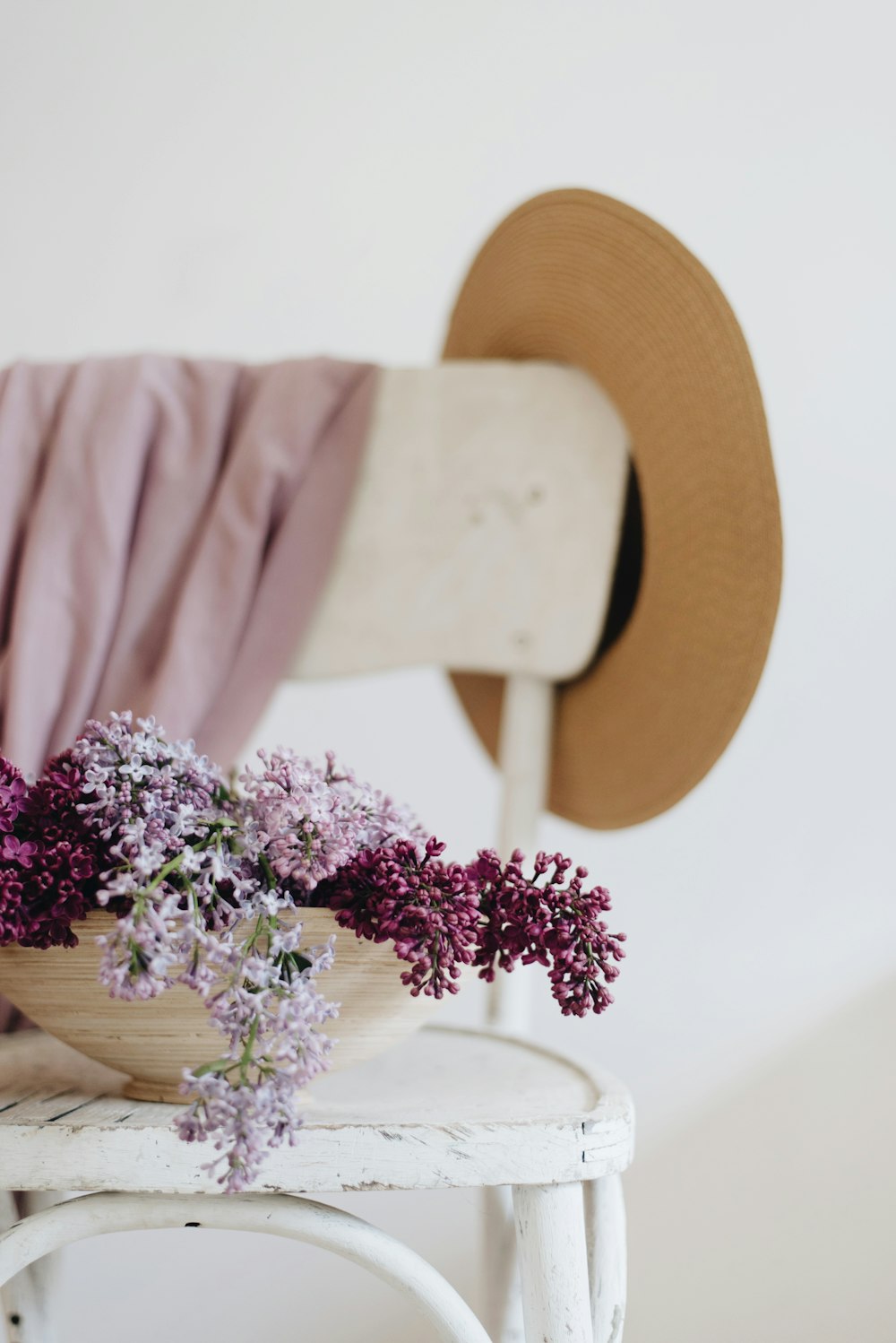 flowers in bowl on wooden chair