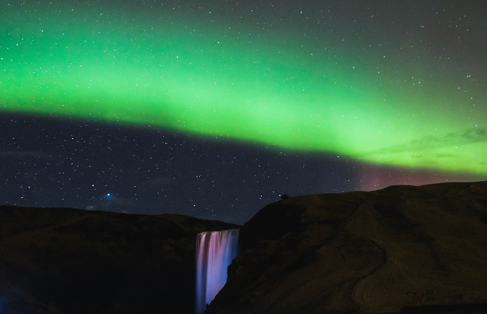 waterfalls on mountain and northern light