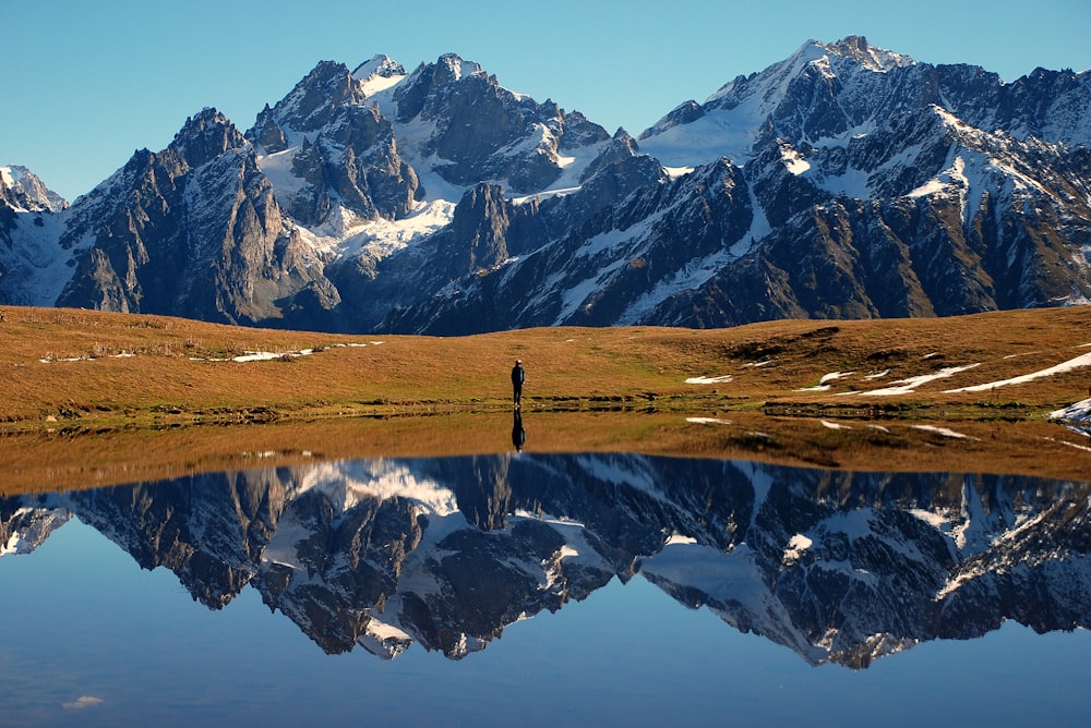 man wearing black shirt standing near the lake