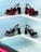 A display of four pairs of high-heeled shoes arranged on a tiered white shelf. The shoes on the top row are decorated with red floral patterns and black bows, while the pairs on the bottom row feature black and white patterns with black bows. The shelves are set against a light blue background.