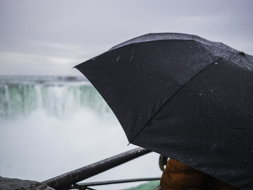 person holding black umbrella