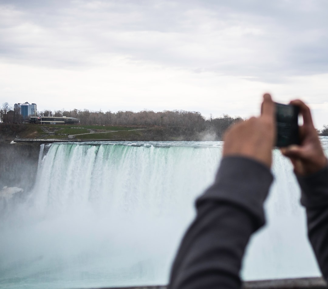 man taking photo to the waterfalls