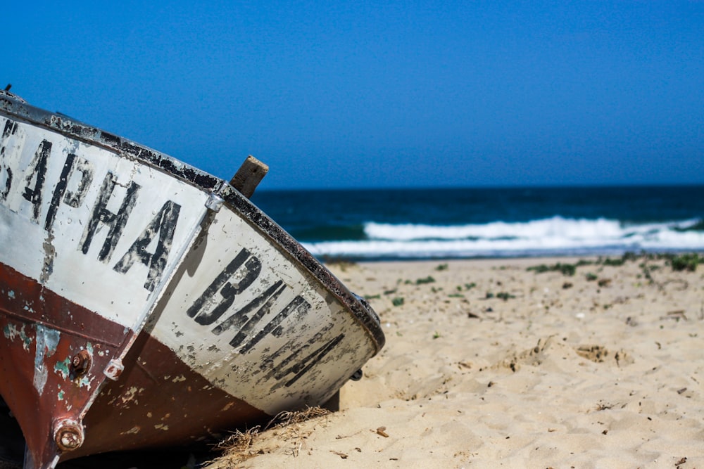 white and brown boat on seashore