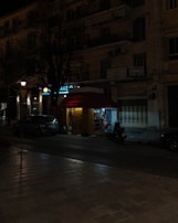 A nighttime city street scene highlighting a Socket2U kiosk outside a popular venue.