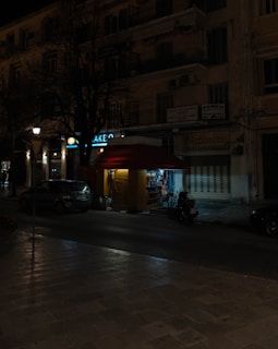 A nighttime city street scene highlighting a Socket2U kiosk outside a popular venue.