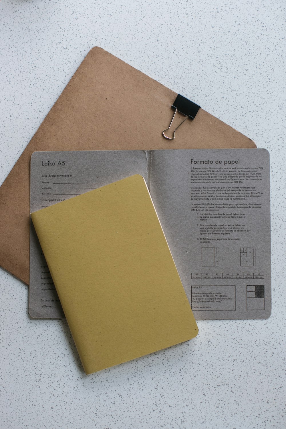 Livro amarelo softbound em papel de impressora cinza