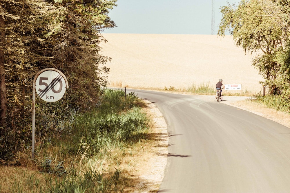 person riding bike near road