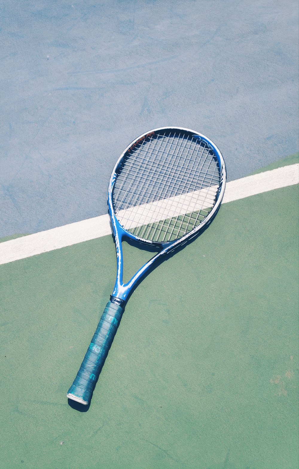 blue tennis racket on green surface