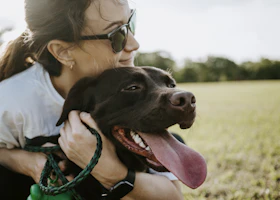 Mujer abrazando a su perro al aire libre