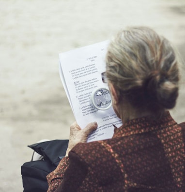 woman in brown top reading paper