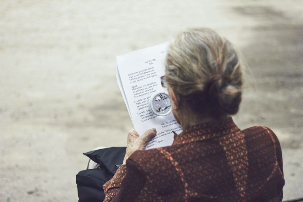 woman in brown top reading paper