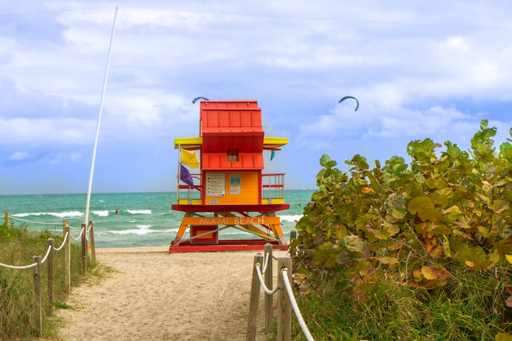 red and yellow lifeguard house in beach during daytime