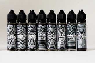 A row of 250ml bottles customized for a birthday party, each with colorful names and fun event messages.