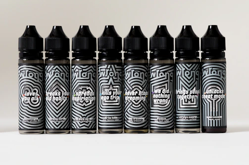 A row of 250ml bottles customized for a birthday party, each with colorful names and fun event messages.